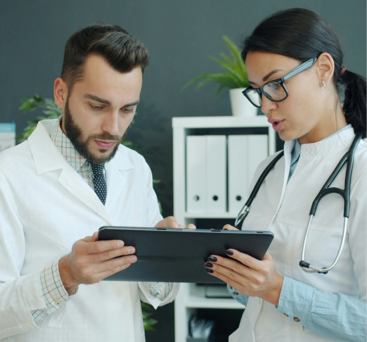 dois médicos olhando um tablet e dialogando