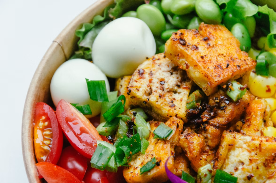 tigela de salada com tomates cereja, ovos cozidos, frango, cebolinha, milho e mais